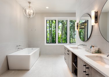 Elegant Bathroom in New Luxury Home with Two Sinks, Bathtub, and Cabinets