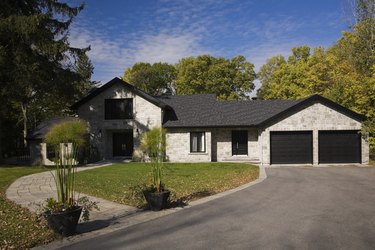 Grey stone luxury home with drive and garden