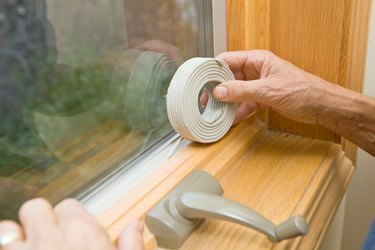 Hands Applying Weather Seal Caulk to Window Frame