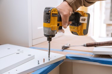 Cropped Hand Of Man Working With Drill On Wood