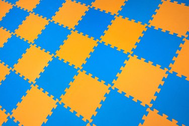 Rubber orange-blue colored floor puzzle. Horizontal layout perspective. Flooring indoors playground.