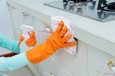Woman cleaning the kitchen cabinet