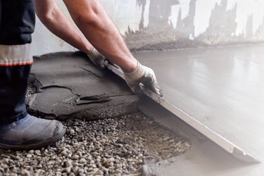 Worker levels a floor cement mortar. Equal floor. Repair of the house.