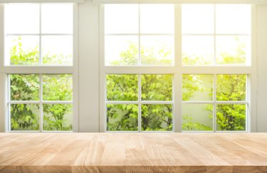 Top of wood table counter on blur window view garden background.