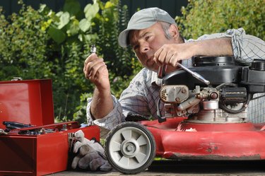 Man working on a lawnmower in the garden.
