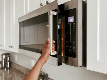 Close-Up of Woman Opening Microwave