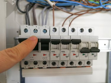 Electric engineer analyzes AC installation inside switch board cabinet