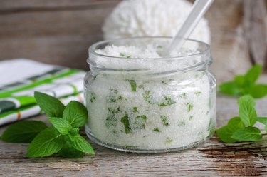 Homemade sugar scrub with mint leaves and essential mint oil