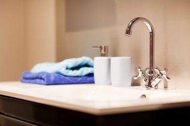 Bathroom sink with chrome faucet and towels