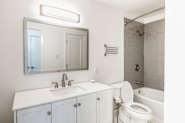 Freshly renovated bathroom with shower, toilet, mirror, faucet and sink