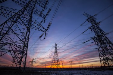 The silhouette of the evening electricity transmission pylon