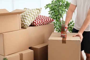 Man packing carton box indoors, closeup. Moving day