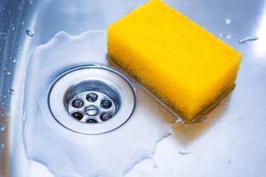 Yellow sponge in kitchen sink close up