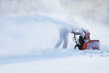 man with a snow blowing machine
