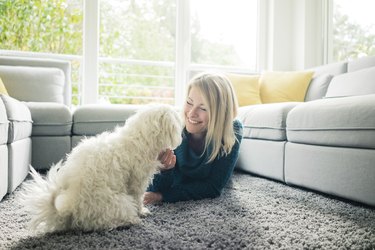 Smiling woman petting her dog in living room