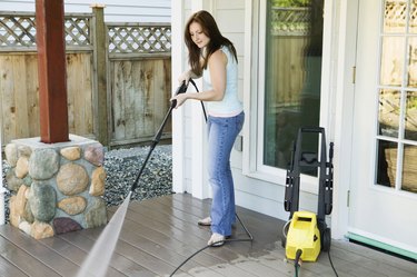 Side profile of a young woman cleaning the porch of her house