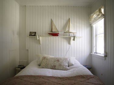 Bedroom with white wood panelling and bed
