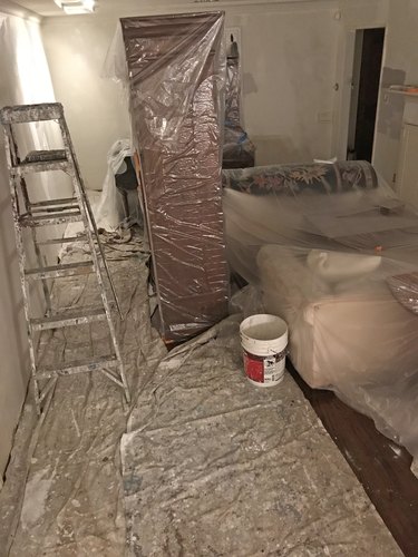 Painting a room with furniture and floors covered