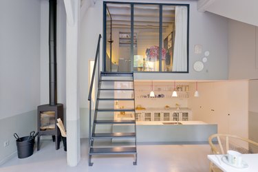 Small living room and kitchen up the stairs and dawn in fashionable loft studio apartment.
