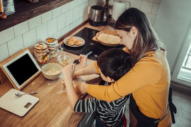 Cute boy baking at home with father