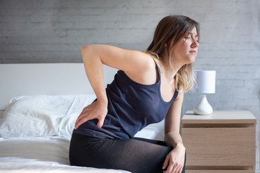 Woman waking up in the morning suffering backache