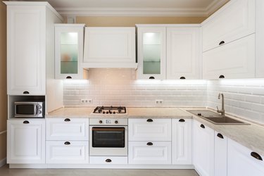 Photo of upscale interior with bright light kitchen cabinet and other designer elements