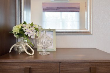 Jewery crystal jar with picture frame and flowers on table
