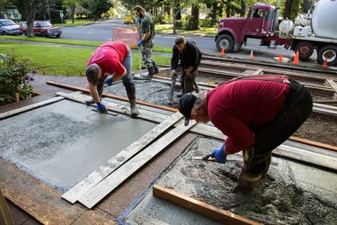 Construction crew pouring concrete driveway