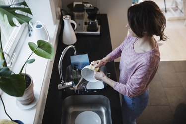 High angle view of woman washing dishes in kitchen at home