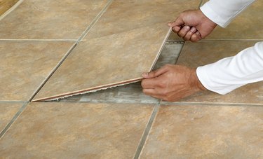 Man removing marble floor tile, close-up