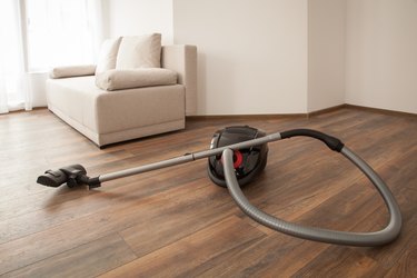 Vacuum cleaner on the wooden floor. Cleaning home