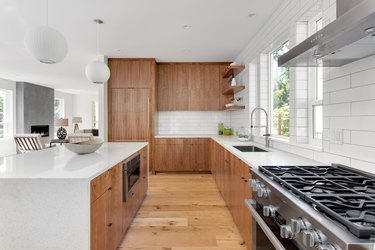 beautiful kitchen in new luxury home with island, pendant lights, and hardwood floors