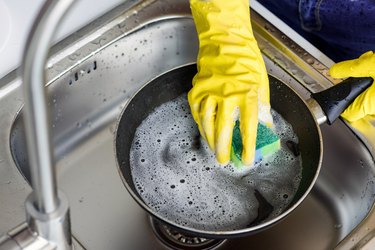 cropped image of woman washing frying pan in kitchen