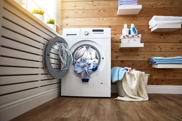 Interior of real laundry room with  washing machine at window at home