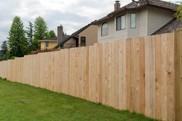 New Cedar wood fence boards along homes in suburban neighborhood