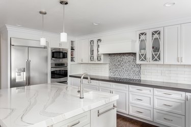 beautiful kitchen in new luxury home with island, pendant lights, and hardwood floors