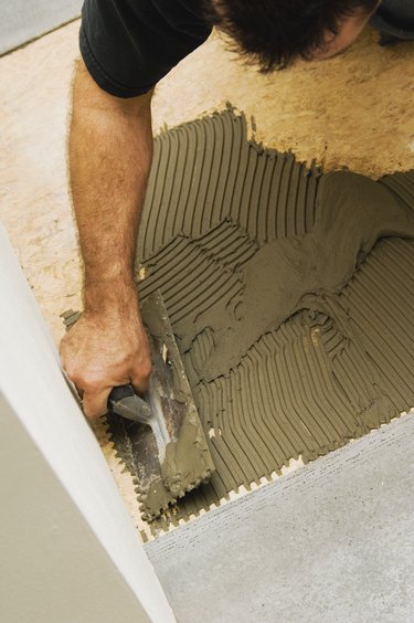 Construction worker laying subfloor