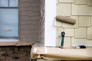 Paint Roller, Brush and Putty Knife rest near New Siding