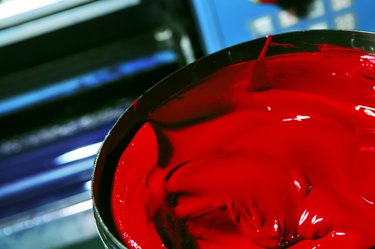 Red paint in an iron pot closeup.