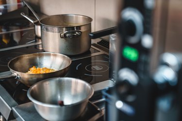 Sauces and soups simmering in restaurant kitchen - Stock photo