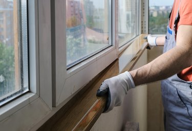 Worker is installing a window sill.