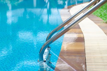 Grab bars ladder in the blue swimming pool