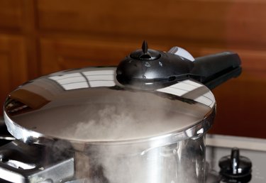 Pressure being released from cooker on hob