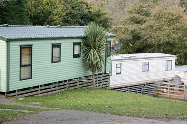 Two mobile homes with wood skirting.