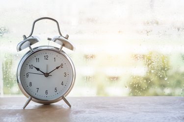 vintage  alarm clock and  classic design near window on wooden floor.