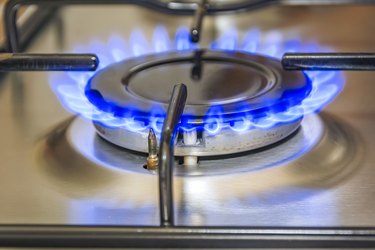 Close-up view of a kitchen cooker with blue flame
