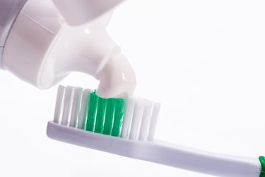 Close-Up Of Toothbrush With Toothpaste Against White Background