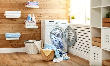 Interior of real laundry room with  washing machine at window at home