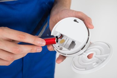 Electrician nolding smoke detector