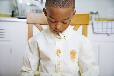 Young Boy Looking at Shirt's Food Stains